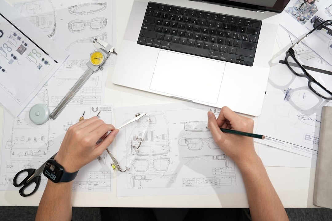Engineer reviewing technical drawings on a laptop screen at a desk